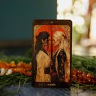 Text "5 wands". Zwei Frauen, Kopf an Kopf, halten einen Stab, mit rotem Hintergrund. Es wirkt wie eine Tarotkarte.