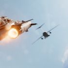 Zwei düsengetriebene Flugzeuge fliegen am Himmel, umgeben von Wolken, mit sichtbaren Feuerschweifen aus den Triebwerken.