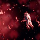 Ein Astronaut schwebt in einem roten Raum mit verstreutem Trümmer. Beleuchtet von einem hellen Licht im Hintergrund.