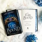 Buch "Fury Bound" von Sable Sorensen, Cover mit zwei goldenen Wölfen und Schmuckstein. Umgeben von blauen Blumen.