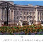 "Buckingham Palace", darunter Kalender für Oktober: 1 bis 31. Im Hintergrund der Palast, davor ein Zaun und blühende Sträucher.