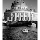 "Bode-Museum" steht über dem Eingang. Ein Kalender für Oktober ist darunter. Ein Boot fährt vor dem historischen Gebäude.