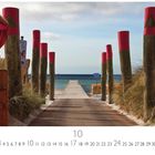 "Weg zum Meer" steht unten links. Ein hölzerner Steg führt zwischen Strandkörben und Dünen zum Meer.