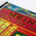 „MEIN B... FÜR IMMER“ in goldener Schrift auf rotem Hintergrund, verziert mit Lichterkette und Fensterillustration.