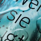 Text: "weil sie lügt" auf blauem Hintergrund. Wassertropfen verzerren den Schriftzug.