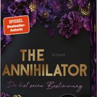 Text: "THE ANNIHILATOR", "Roman", "Du bist seine Bestimmung", "SPIEGEL Bestseller-Autorin". Lila Blumen gestalten den Hintergrund.