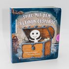 „SPIEL MIT DEM KLEINEN GESPENST“. Ein freundliches Gespenst schaut aus einer geöffneten Truhe, umgeben von Spinnweben.