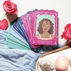 Ein Stapel Spielkarten. Vorderste Karte: "Fake Dating. Seit Wochen... Spiel längst Ernst geworden war." Piktogramme, Rosen, Tuch.