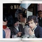 Text: "O. Henry's". Eine Gruppe von Menschen in einem Café, darunter eine Frau mit Sonnenbrille und ein Mann mit Zigarette.