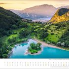 "Oktober" steht unten links. Landschaft mit grünen Hügeln, klarer See und Dorf in den Bergen bei Sonnenuntergang.