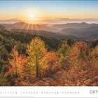 "Oktober" steht unten rechts. Kalender mit Herbstlandschaft, Sonnenuntergang über buntem Wald und Bergen.