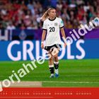 Text: "Vorpresabbildung". Eine Fußballspielerin in weißem Trikot auf einem Spielfeld, Zuschauer im Hintergrund.