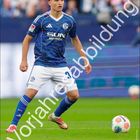 "Vorjahresabbildung" in großen Buchstaben, unten ein Kalender für Oktober. Fußballspieler in blauem Trikot auf dem Rasen.