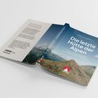 Titel: "Die letzte Hütte der Alpen". Hintergrund: Berglandschaft, Logo unten. Autoren: Matthias Balinger, Bertram Klaus.