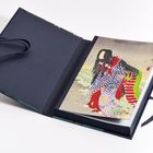 Illustration eines elegant gekleideten Menschen in einem aufgeschlagenen Buch mit schwarzem Einband und Bändern.