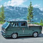 Ein grüner Van mit Hirschlogo steht vor einer alpinen Berglandschaft mit blauen Himmel und grünen Bäumen.