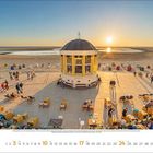 10 Oktober 2023. Kalenderansicht einer Strandpromenade im Sonnenuntergang, Menschen sitzen und spazieren.