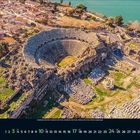Oktober 2023 Kalender. Antikes Amphitheater aus der Vogelperspektive, umgeben von Ruinen und einem nahegelegenen Gewässer.