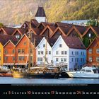 "Knøsesmauet", "Xhibition", "Stadt", bunte Häuser, älteres Schiff und Boote im Hafen, leicht bewaldete Hügel im Hintergrund.