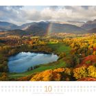Kalender für Oktober mit Landschaftsfoto: Ein See, bunte Herbstbäume, Berge im Hintergrund, bunter Regenbogen.