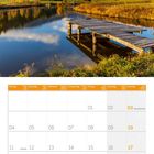 Oktober 2027 Kalender mit Feiertagen; Landschaft mit See, Steg, Herbstbäumen, und Bergen unter blauem Himmel.