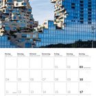 Kalender für Oktober 2027. Foto von modernen, terrassenförmigen Gebäuden mit blauen Glasfronten vor blauem Himmel.