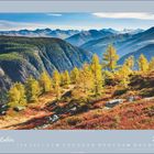 "Oktober 2027". Eine Berglandschaft mit herbstlichen Farben, gelben Lärchen, grünen Wäldern und Bergen im Hintergrund.