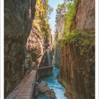 Leutaschklamm, Wetterstein, Bayern, Deutschland. Kalender: Oktober 2027. Eine Schlucht mit blauem Fluss und Holzsteg.