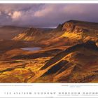 "Golden Quiraing" und Zitat von Ross Hoddinott über Perfektion. Landschaft mit Hügeln, Tal und See unter dramatischem Himmel.