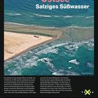 "Ostsee. Salziges Süßwasser." Küstenlinie mit türkisblauem Wasser, Wellen am Sandstrand, Text mit Infos zur Ostsee.