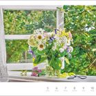 Juli, 27. Woche. Ein Sommerblumenstrauß in einer Vase auf einer Fensterbank mit Blick auf grünes Laub. Rechts eine Schere.