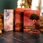 Text: "MAUDE HIRST, INTUITIVE WHISPERS ORAKEL GUIDEBOOK." Zwei bunte Kartenstapel; ein Baum im Hintergrund.