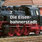 Text: "7 Die Eisenbahnerstadt Von Werner Benecke". Eine schwarze Dampflokomotive vor einem Ziegeldach.