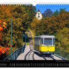 Oktober, Standseilbahn vor buntem Herbstlaub, Kalenderdaten unten, gelbe Bahn auf Schienen, Gebäude im Hintergrund.