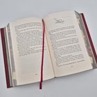 Ein aufgeschlagenes Buch zeigt auf der rechten Seite die Überschrift "AKT II: SZENE XIII" und darunter fortlaufenden Text.