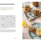 "Birgits Dinkel-Quark-Brötchen. Einfache Rezepte. Bild: Brötchen mit Körnern auf einem Blech, daneben ein Glas Saft."