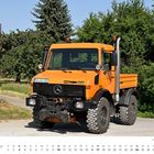 Kennzeichen: OG-GO 222. Oktober Kalenderblatt. Orangefarbener Unimog-LKW auf einem Weg, Bäume und ein Backsteinhaus im Hintergrund.