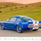 Text: "Oktober", "1965er Ford Mustang Custom", "3GEL085". Ein blauer Ford Mustang mit weißen Streifen, auf einer Straße vor grünen Hügeln.
