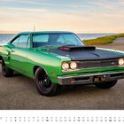 Text: "SIX PACK" auf der Motorhaube, "XKL 740" auf dem Nummernschild. Ein grüner 1969er Dodge Super Bee vor Meer und Straße.