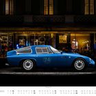 Text: "Gran Caffè Verbano", "Campari". Ein blauer Sportwagen mit der Nummer 74 steht vor einem beleuchteten Café.