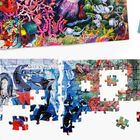 Eine Puzzle-Anleitung zeigt bunte Ozeanszenen mit Pinguinen, Orcas und Unterwassertieren auf einem teilweise fertiggestellten Puzzle.