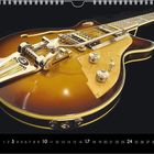 Kalenderseite mit brauner Elektrogitarre und goldenen Details auf schwarzem Hintergrund, zeigt den Monat Oktober.