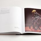 Text: "Portrait of a Woman seeking a New Normality, 2024." Kunstbuch, zeigt eine Skulptur mit tentakelartigen Formen und menschlichem Kopf.