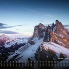 "Seceda - 2.519 m (Italien) 11" über einem schneebedeckten Bergpanorama bei Sonnenaufgang. Unten ein Monatskalender.