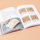 Text: "Obi Wrap" und "HOW TO MEASURE PAPER FIT". Offenes Buch über Geschenkverpackung mit Bildern von Anleitungen und Materialien.