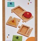 „Montessori by Eichhorn“ mit geometrischen Holzformen und bunten Knöpfen. Ab 1 Jahr. Oberer Bereich zeigt ein Logo.