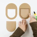 "Bastelkleber Hobby Glue" steht auf einer gelben Flasche. Zwei Hände berühren Holzformen auf einer weißen Fläche.