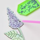 Zahlen auf einer Blumenform: Blütenblätter mit "5", Blätter mit "A". Pinker Stift daneben, grüne Schale mit Perlen.