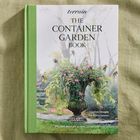 "terrain THE CONTAINER GARDEN BOOK; Creative Designs for Every Season; Melissa Bartley & Greg Lehmkuhl." Ein Buch mit grünem Buchrücken, darauf ein prachtvolles Pflanzenarrangement in einem dekorativen Gefäß.