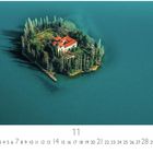 Visovac; 11; Insel im blauen Wasser mit Gebäude, umgeben von Bäumen. Kleiner Anlegesteg, dichter Wald.